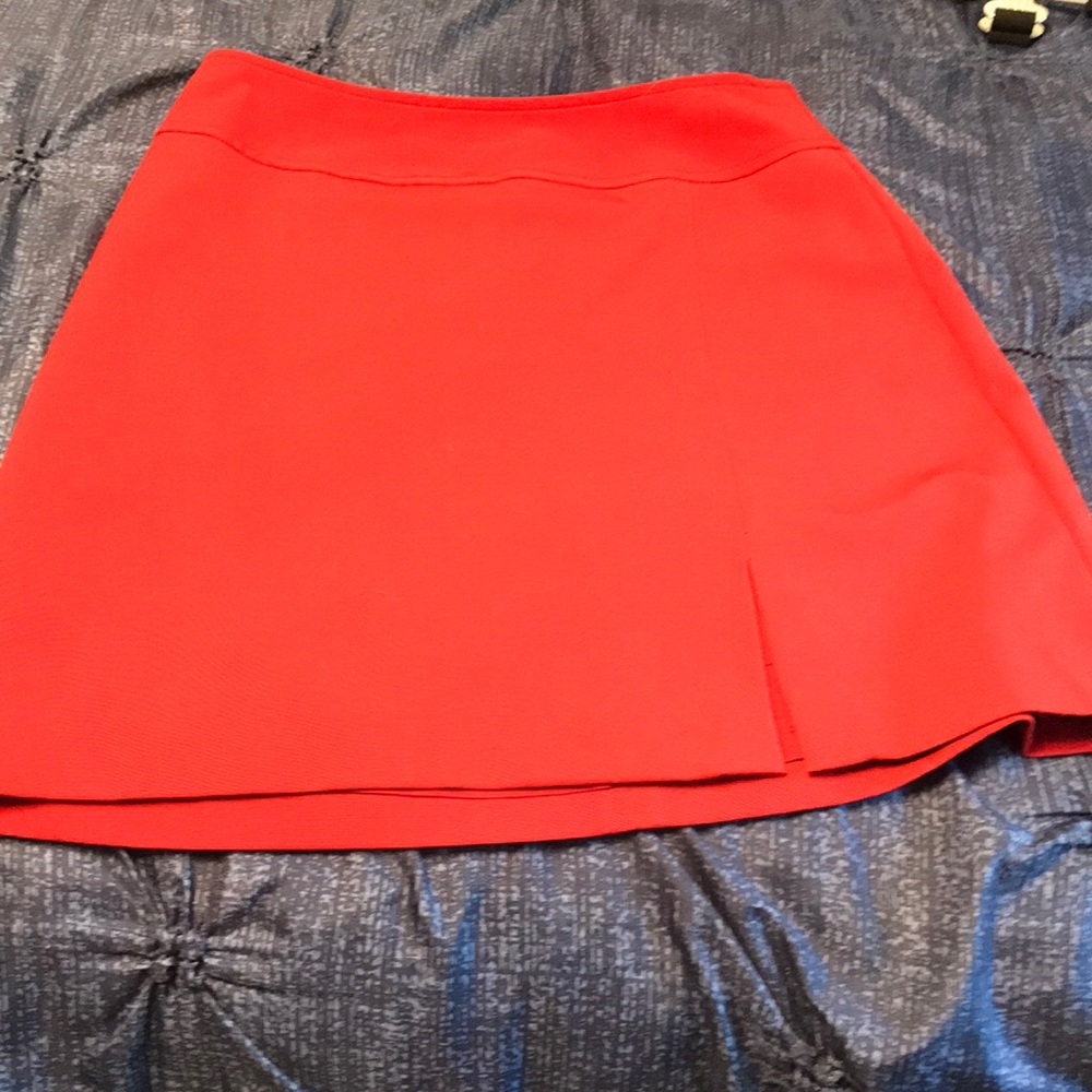 One red short skirt with a slit in the front size 1/2